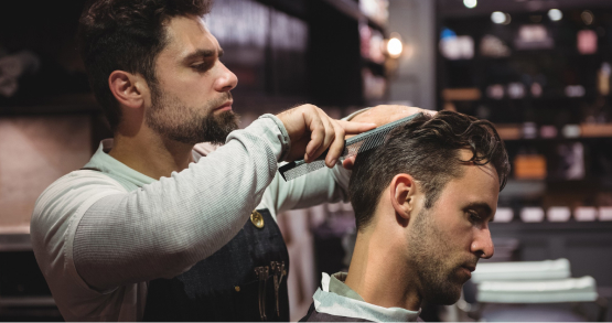 Professional hairstylist giving modern men haircut in Kadubeesanahalli