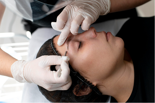 Applying warm wax for hair removal during threading and waxing in Mahadevapura service