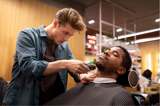 Barber shaping a fade during professional haircuts for men in Whitefield